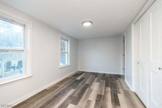 unfurnished bedroom featuring dark wood-type flooring and a closet