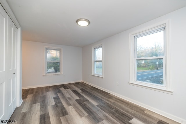 spare room featuring dark hardwood / wood-style flooring and a wealth of natural light