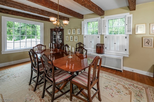 dining room featuring beam ceiling, light hardwood / wood-style floors, and an inviting chandelier