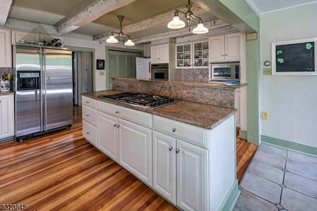 kitchen featuring an inviting chandelier, white cabinets, hanging light fixtures, beamed ceiling, and stainless steel appliances