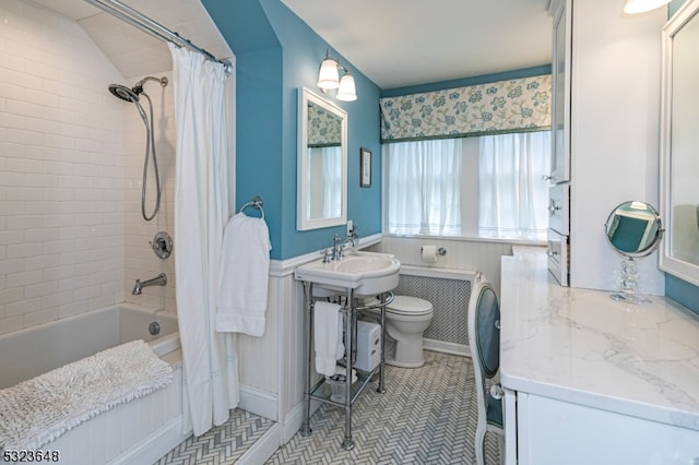 full bathroom with vaulted ceiling, shower / tub combo with curtain, sink, tile patterned flooring, and toilet