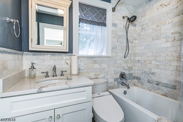 full bathroom with toilet, vanity, tile walls, and tiled shower / bath