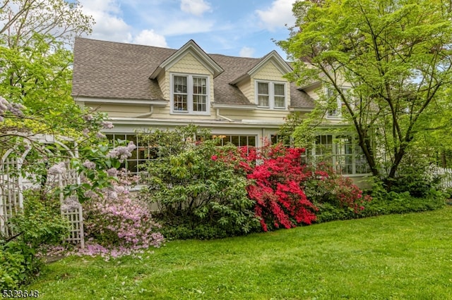 cape cod house with a front yard