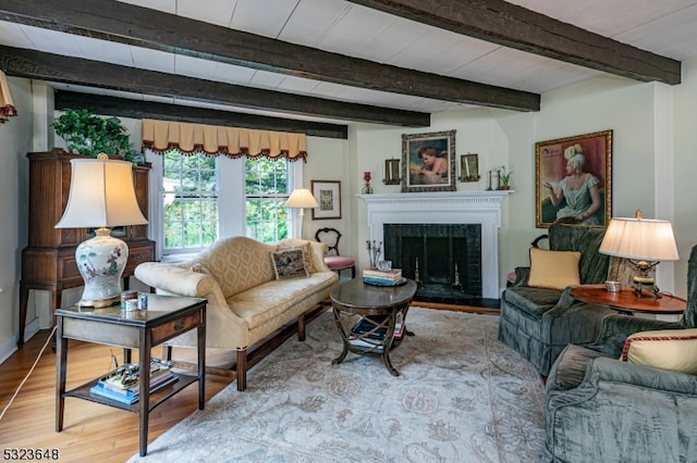 living room featuring beamed ceiling and light hardwood / wood-style floors