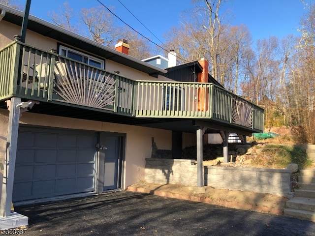 back of property with a garage and a deck