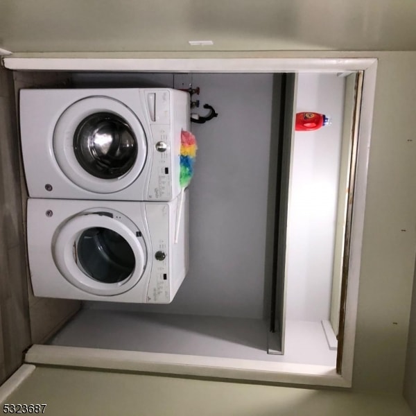 clothes washing area with stacked washer and dryer