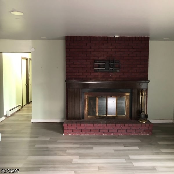 interior details featuring a fireplace, hardwood / wood-style flooring, and a baseboard radiator