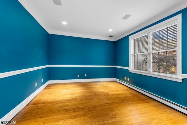 unfurnished room with hardwood / wood-style flooring, baseboard heating, and crown molding