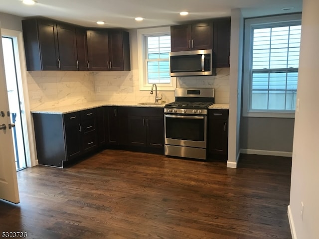 kitchen featuring sink, appliances with stainless steel finishes, decorative backsplash, and dark hardwood / wood-style floors