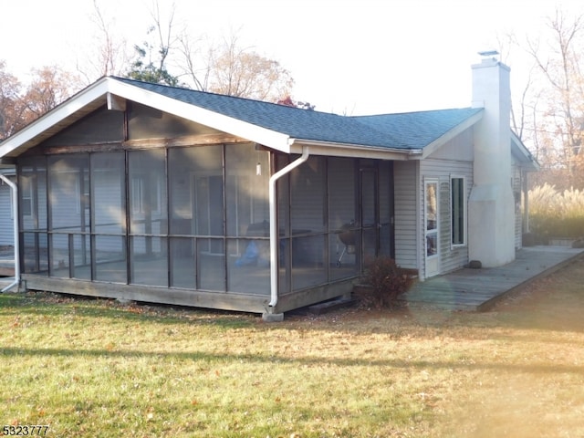 view of side of home featuring a lawn and a sunroom