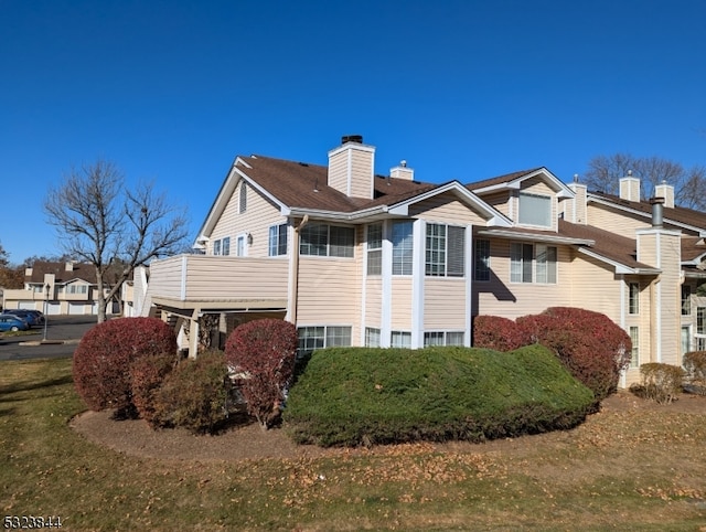 view of home's exterior with a lawn and a balcony