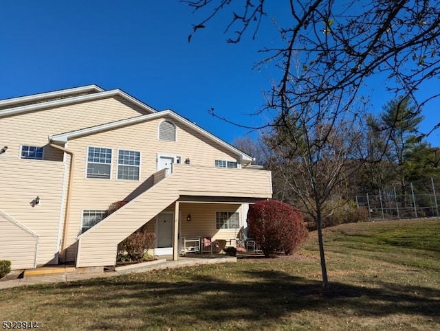 rear view of property featuring a lawn