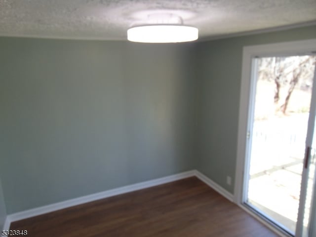 unfurnished room with wood-type flooring and a textured ceiling