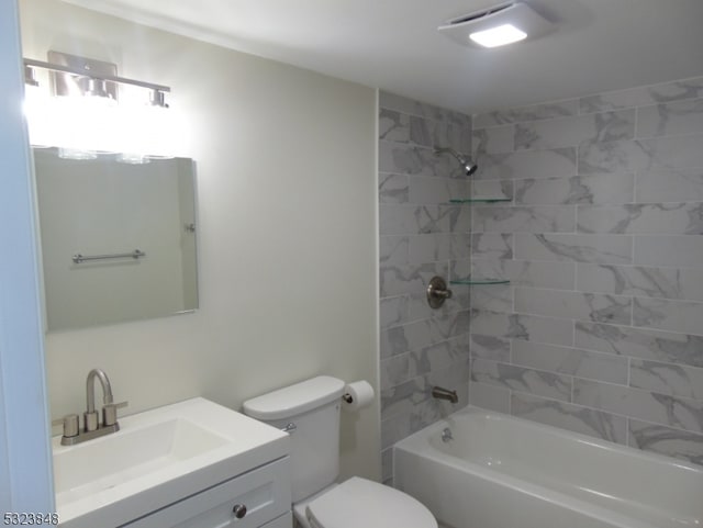 full bathroom featuring vanity, tiled shower / bath combo, and toilet