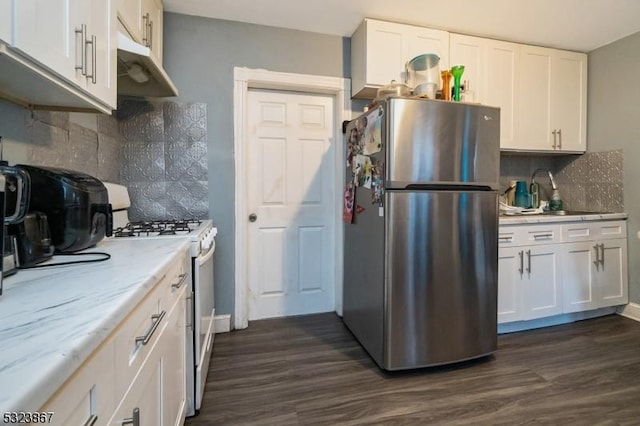 kitchen with white range, white cabinetry, and stainless steel refrigerator