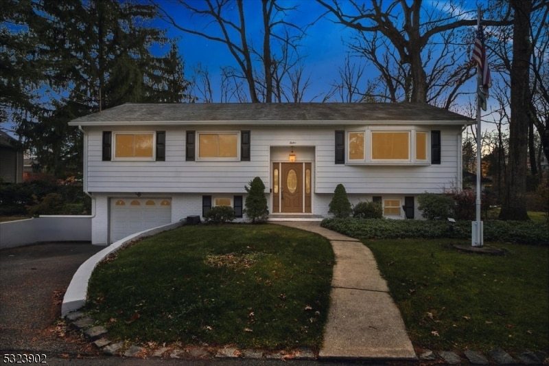 bi-level home featuring a garage and a yard