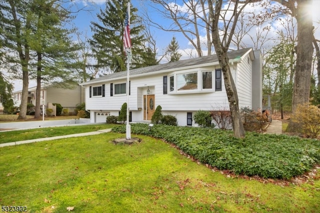 bi-level home featuring a garage and a front yard