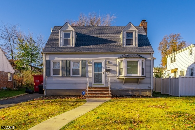 cape cod home featuring a front yard