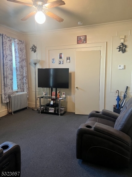 living room with carpet flooring, radiator, ornamental molding, and ceiling fan