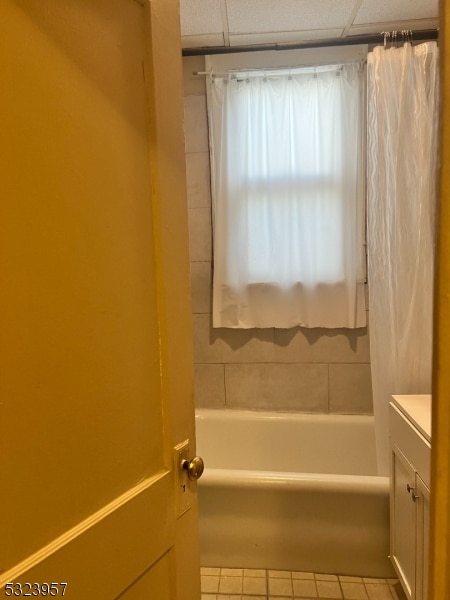 bathroom featuring a paneled ceiling, tile patterned flooring, shower / bathtub combination, and vanity