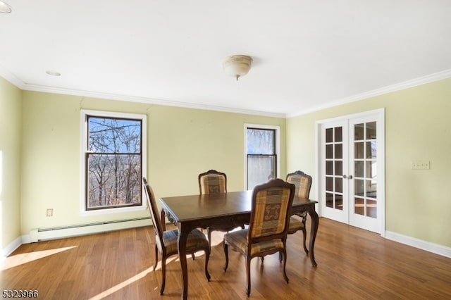 dining space with a wealth of natural light, hardwood / wood-style floors, and a baseboard heating unit