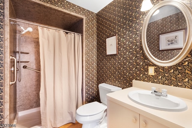 bathroom featuring vanity, toilet, and walk in shower