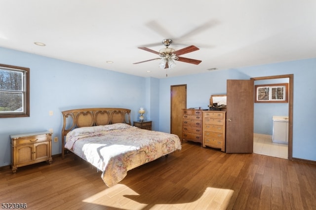 bedroom featuring hardwood / wood-style floors, ceiling fan, and ensuite bathroom