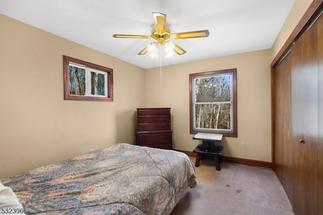 carpeted bedroom featuring ceiling fan and a closet