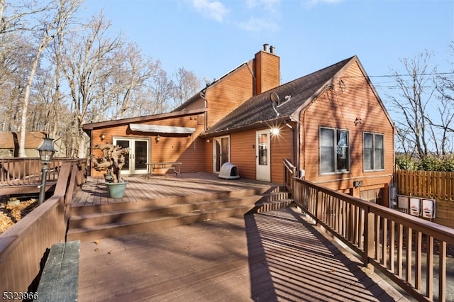 rear view of house featuring a wooden deck and french doors