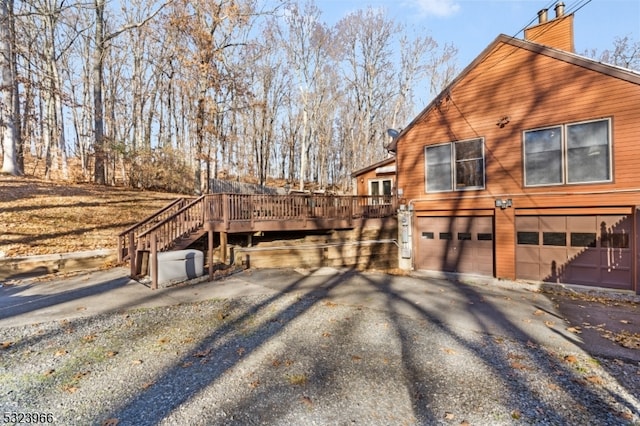 view of property exterior with a garage and a wooden deck