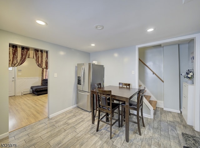 dining space featuring light wood-type flooring and a baseboard heating unit