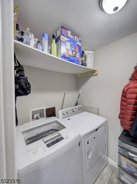 laundry area with light hardwood / wood-style flooring and washing machine and dryer