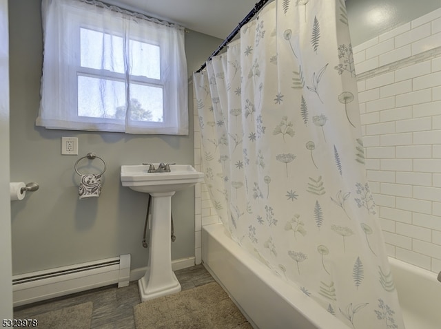 bathroom with a baseboard heating unit and shower / bathtub combination with curtain