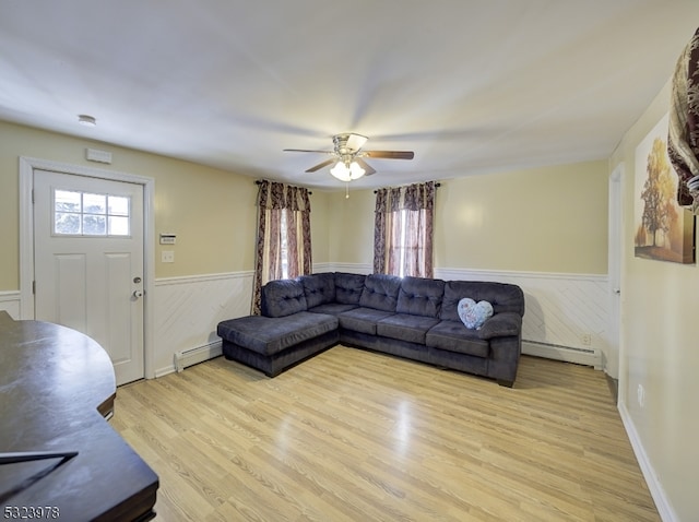 living room with light wood-type flooring, a baseboard radiator, and ceiling fan