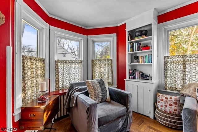 living area featuring parquet flooring, a healthy amount of sunlight, and crown molding