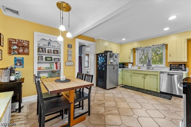 kitchen featuring green cabinets, sink, beam ceiling, appliances with stainless steel finishes, and decorative light fixtures