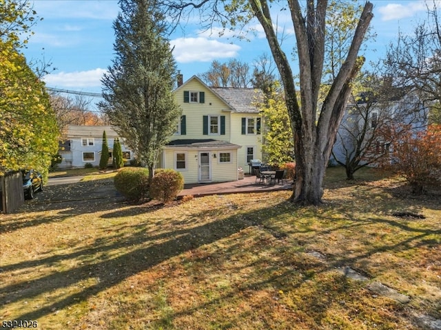 back of property with a yard and a patio area