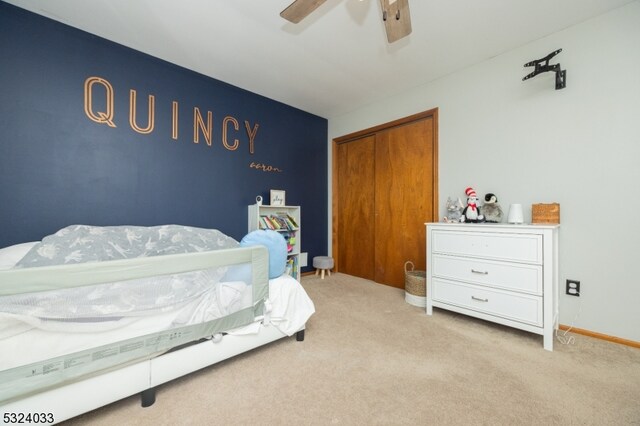 carpeted bedroom with ceiling fan and a closet