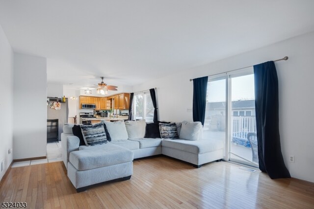 living room with ceiling fan, light hardwood / wood-style floors, and plenty of natural light