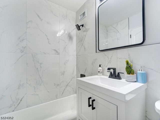 full bathroom with toilet, tile walls, tiled shower / bath combo, vanity, and backsplash