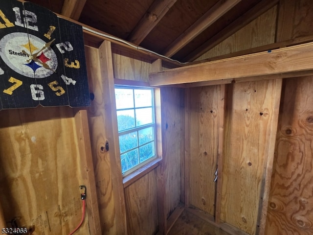 interior space featuring beamed ceiling, wood walls, and wood ceiling