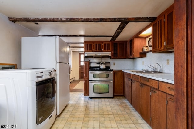 kitchen featuring white refrigerator, sink, tasteful backsplash, stainless steel stove, and washer / dryer