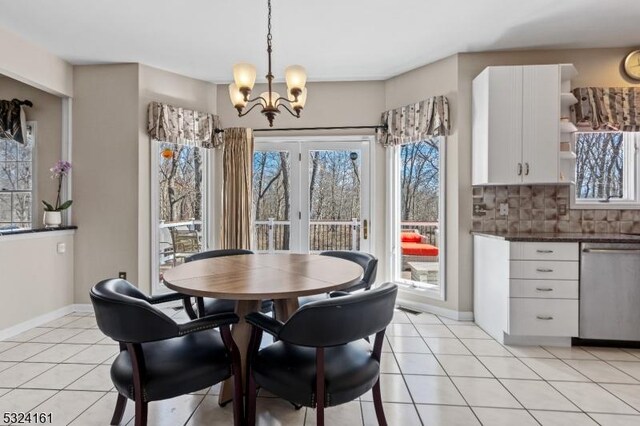 dining room with light tile patterned floors, baseboards, and an inviting chandelier