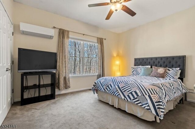 carpeted bedroom with ceiling fan, an AC wall unit, and baseboards