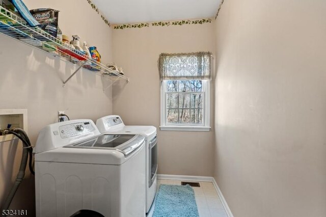 laundry area featuring laundry area, washing machine and dryer, visible vents, and baseboards