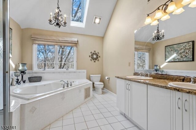 full bathroom featuring toilet, a sink, tile patterned flooring, vaulted ceiling, and a notable chandelier