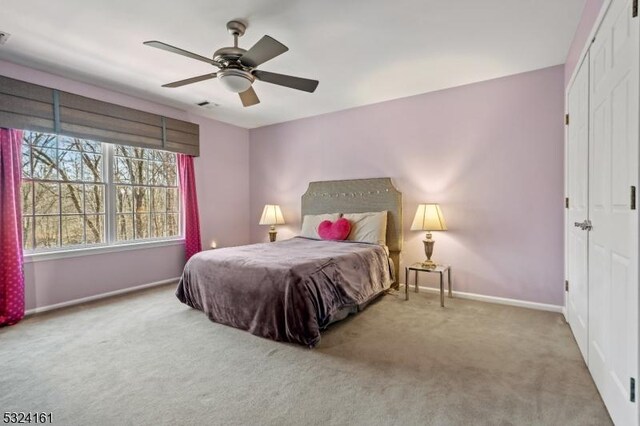 carpeted bedroom featuring visible vents, a ceiling fan, and baseboards