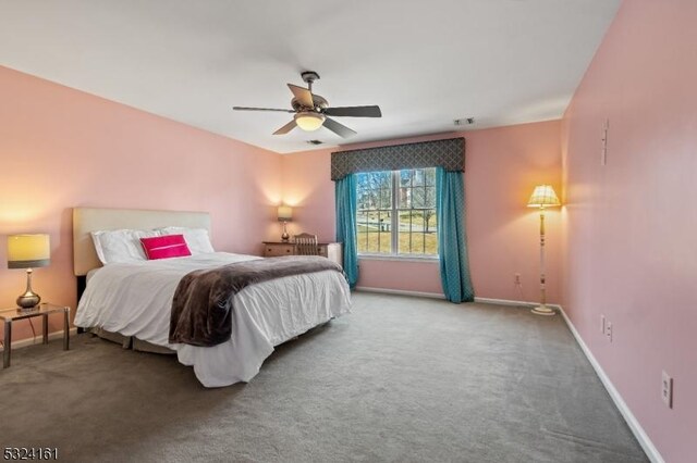 carpeted bedroom with visible vents, baseboards, and ceiling fan