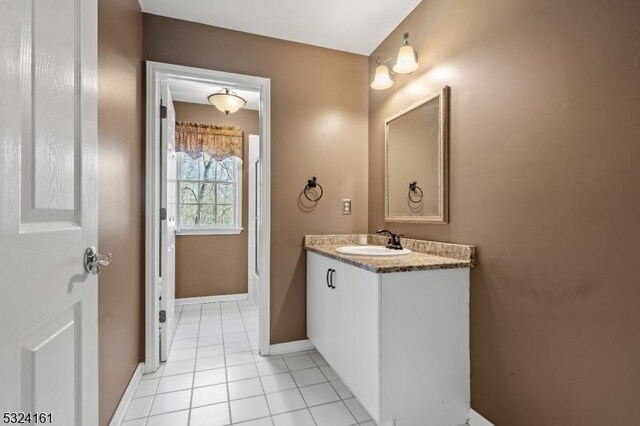 bathroom with vanity, tile patterned floors, and baseboards