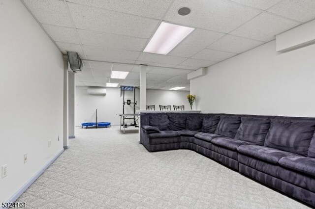 living room featuring an AC wall unit, carpet flooring, a paneled ceiling, and baseboards